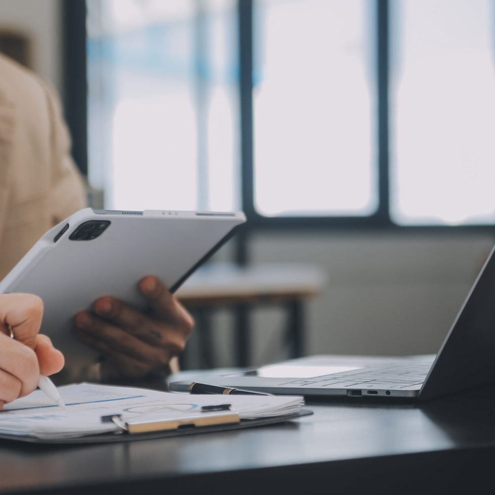 Entrepreneur Asian businessman and businesswoman discussing new business project in tablet in modern Meeting In Modern Office, Asian business casual concept.